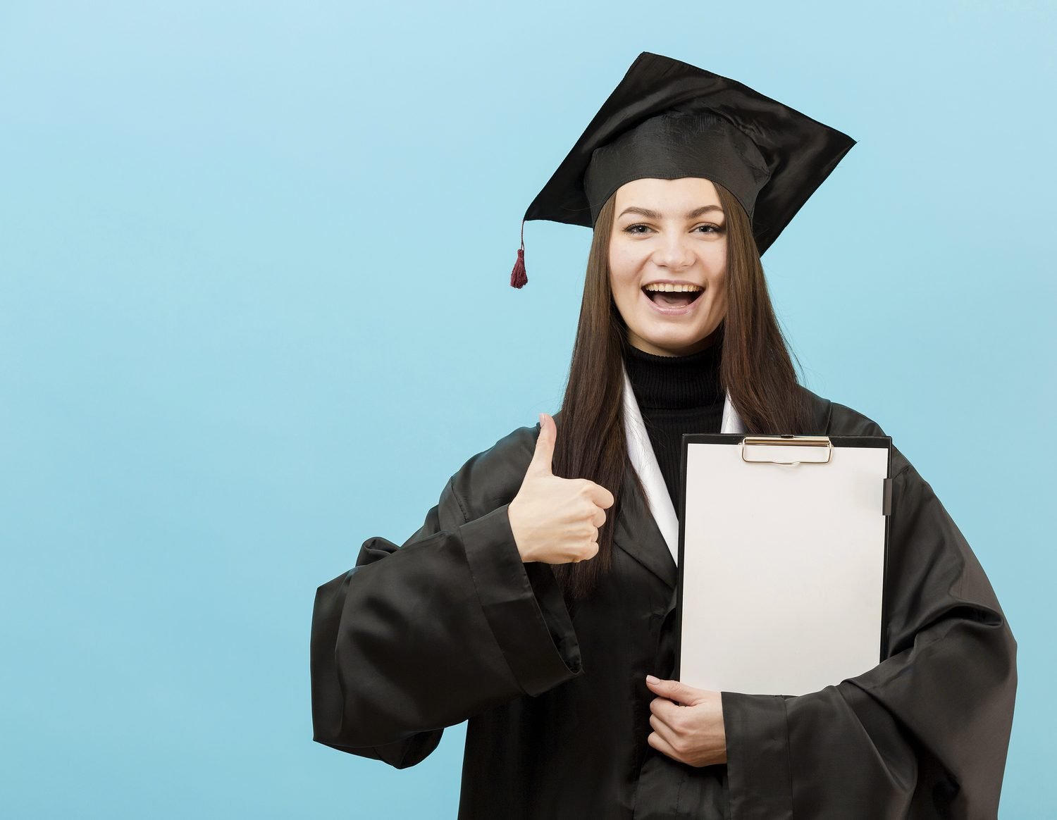 Graduada feliz con el pulgar arriba y una carpeta en la mano