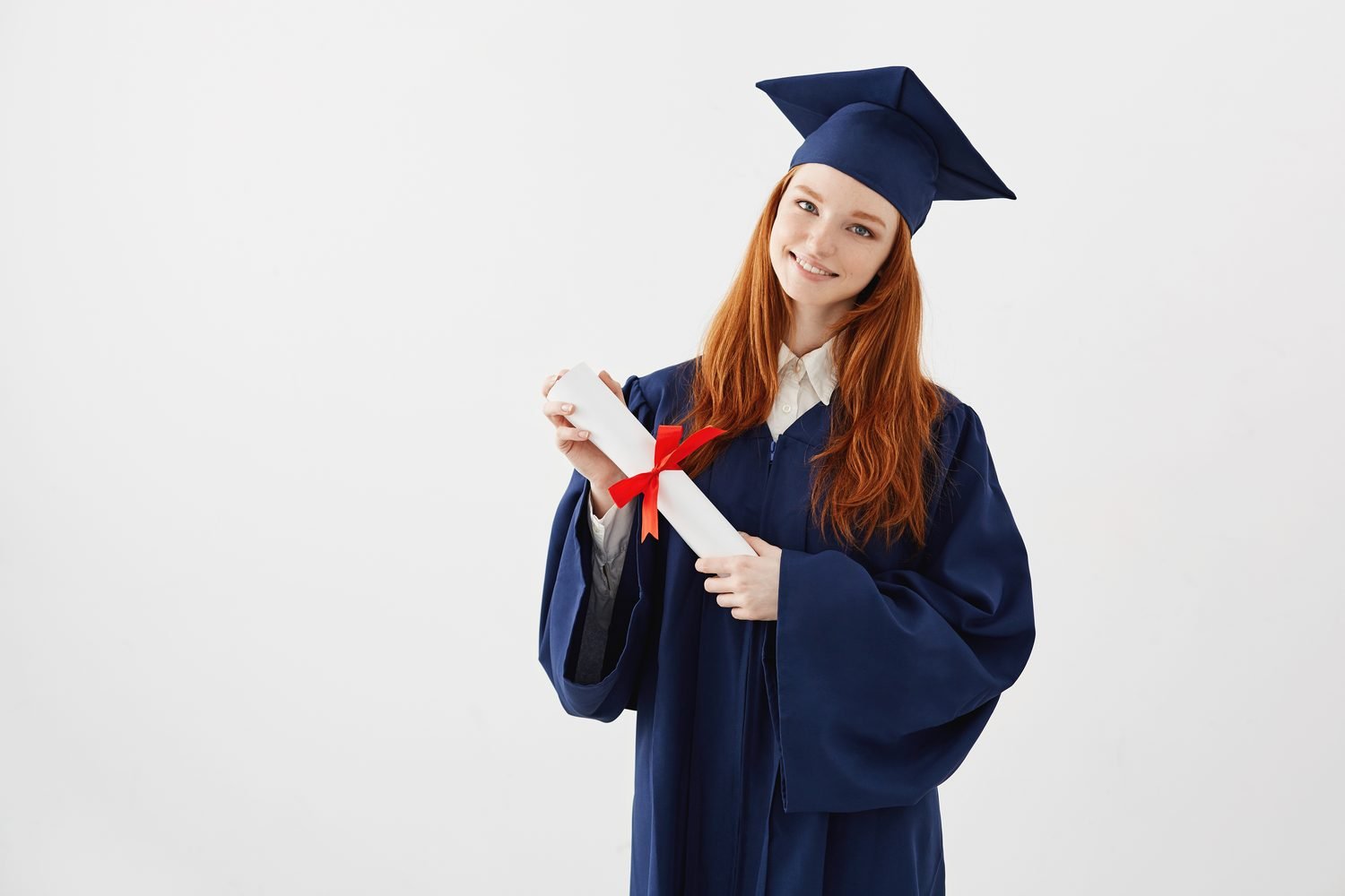 Graduada pelirroja con toga azul sosteniendo su diploma